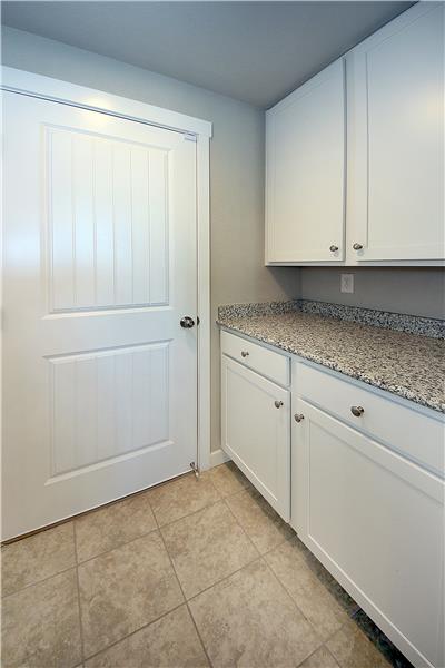 Convenient drop zone area between the garage and kitchen with granite and cabinetry