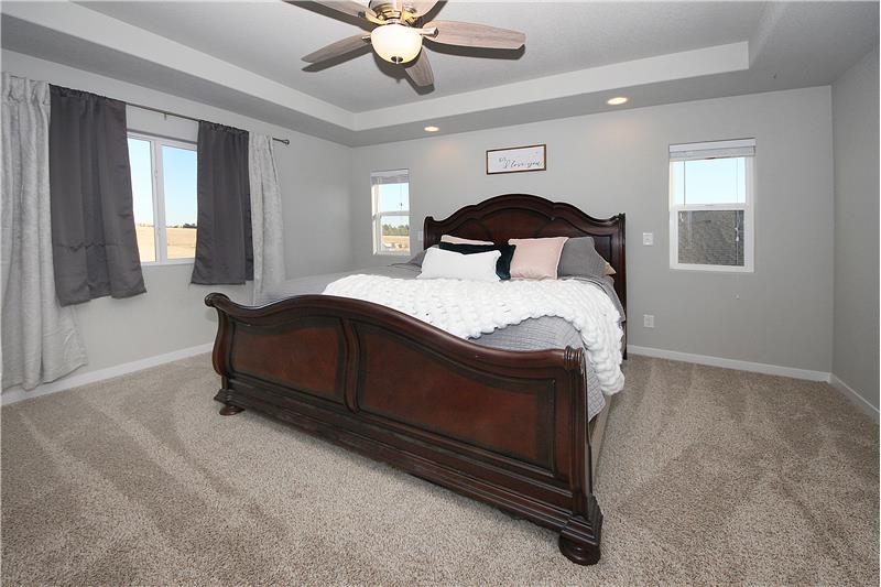 Master bedroom with plentiful windows, recessed lighting, and a ceiling fan