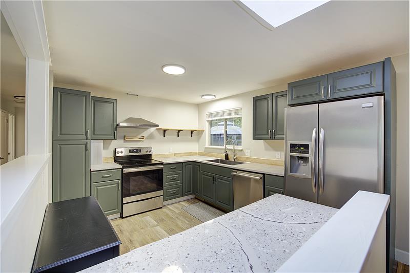 Updated Kitchen, w/new cabinets, counters, flooring, over looks large patio