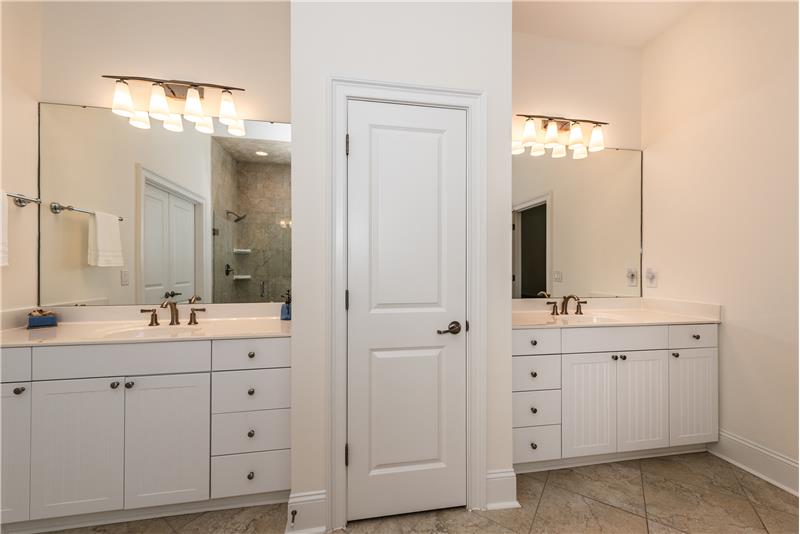 Dual vanities in master bath with generous storage flank a linen closet.