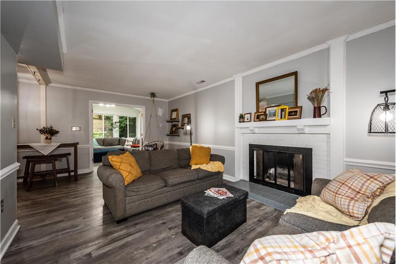 Spacious, open living room with gas log fireplace and luxury vinyl plank flooring.