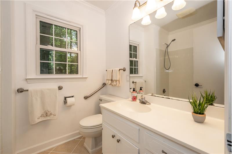 Master bathroom features updated light fixture, tile floor.