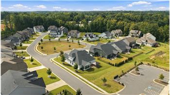 Aerial view of the corner home situated at the start of two cul-de-sac streets across from common space.