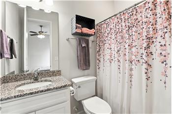 En-suite bathroom in main floor bedroom provides privacy for guests or family members. Tub/shower, vanity with granite counter.