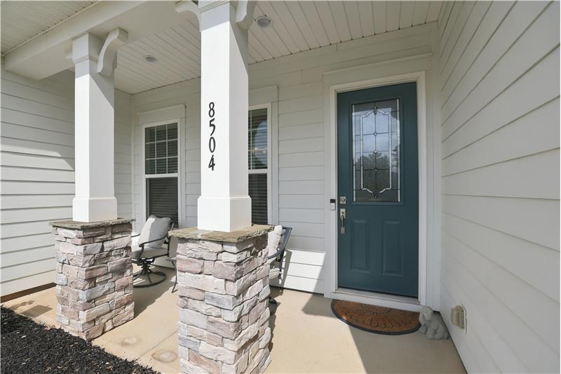 Welcoming entrance with a covered, rocking-chair front porch offers space to sit, relax and unwind.