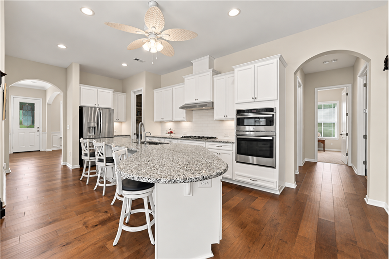 The heart of the home: expansive kitchen with granite counters, huge island, plenty of prep space, room for everyone to join in.