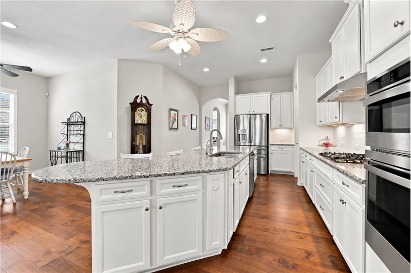 Kitchen features stainless steel appliances: wall oven + microwave, 5-burner gas cooktop, hood, dishwasher, French door fridge.