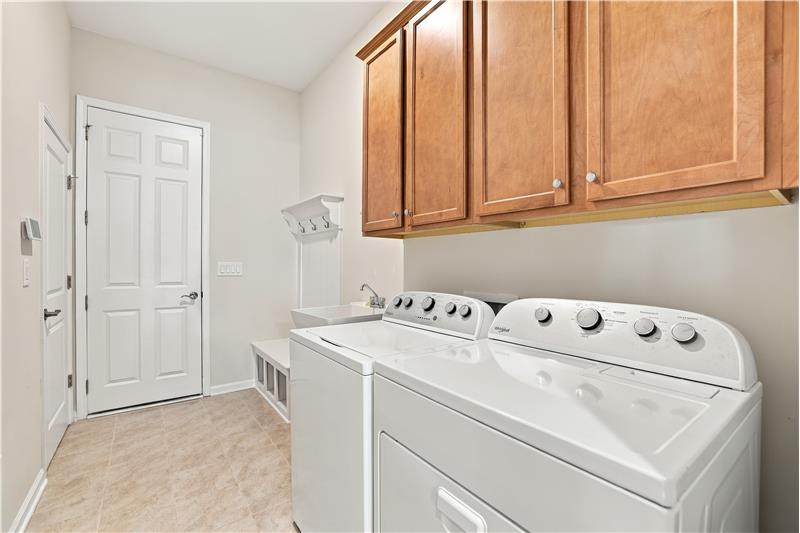 Drop zone/laundry room includes cabinet and shelf storage, a soaking tub, room for large washer/dryer.