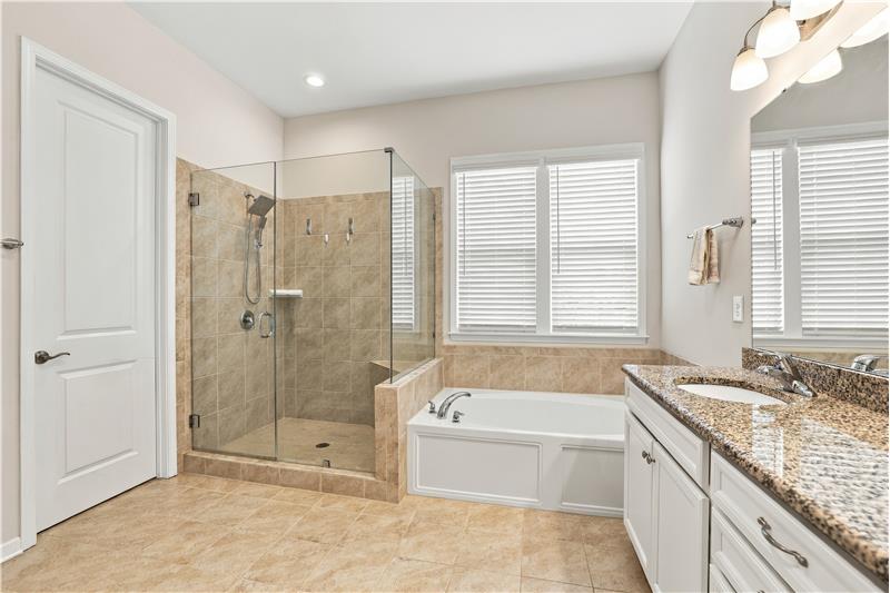 Primary bath features frameless walk-in shower, soaking tub, double sink vanity, generous counter and storage space, private WC.