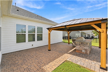 Patio area with built-in grilling center, custom gazebo, brick pavers extend the home's living and entertaining space.