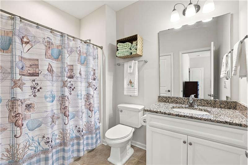 Bathroom shared by the two bedrooms situated on the home's upper floor. Tub/shower, vanity with granite counter, tile floor.