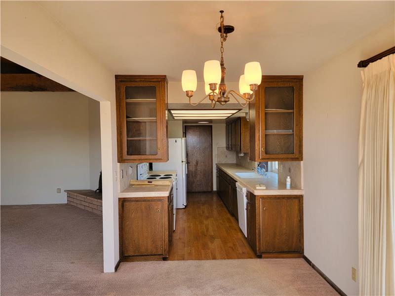 Typical kitchen design of mid 70's; today, that wall would not be there.  An island would be in its place. Pretty simple really.