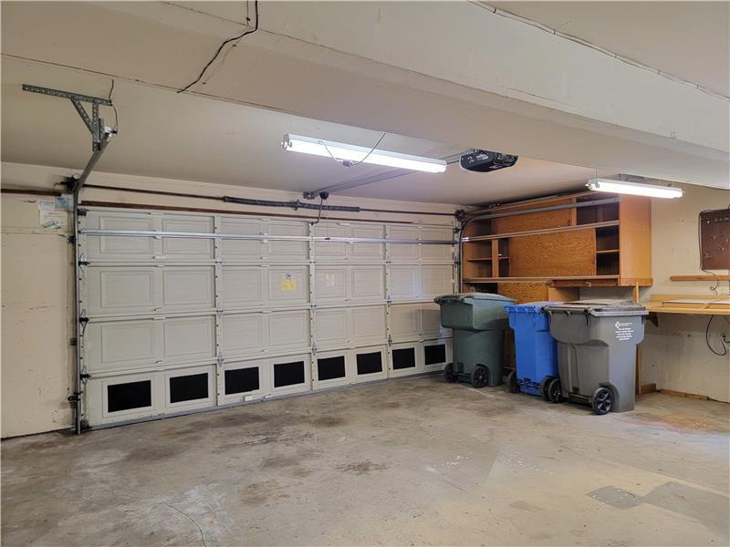 Additional Storage Space is found in built-in Garage cabinets alongside two workbenches!