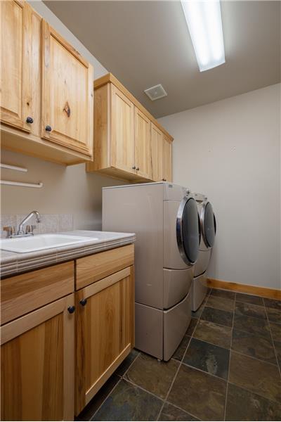 Laundry room off the garage that has a kitchen sink