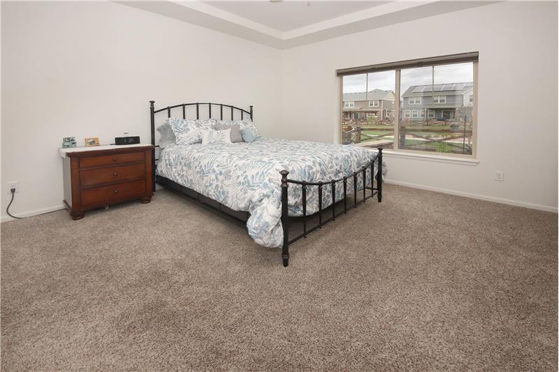 The main level Master Bedroom features neutral carpet, a lighted ceiling fan, and 4pc spa Bathroom