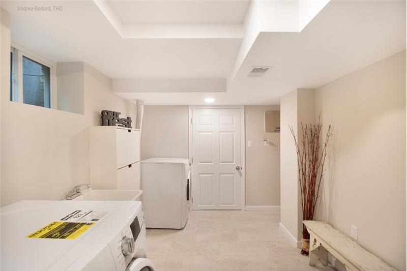 Large laundry/mud room features new ceramic tile, recessed lights...