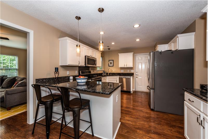Updated kitchen with stainless steel appliances, breakfast bar seating.
