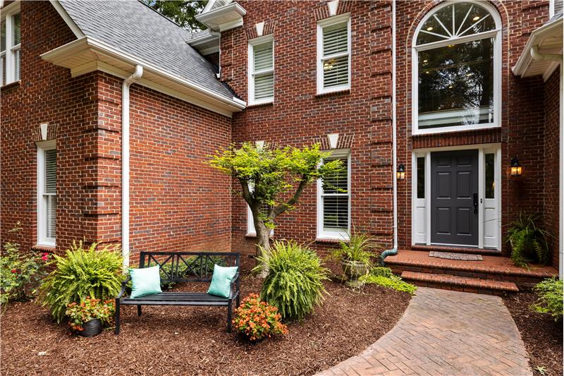 Entrace: lush landscaping; brick walk-way to home's entrance.