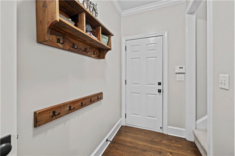 Entrance hall from garage provides access to back staircase and a large laundry room.