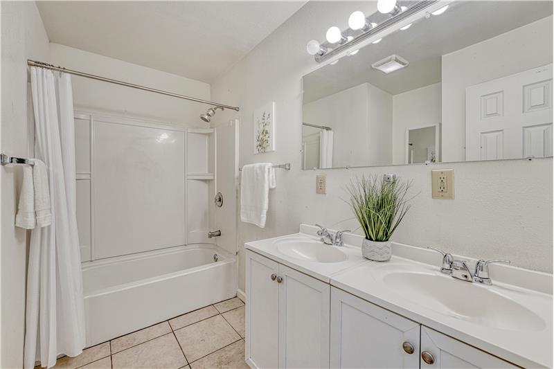 Large Bathroom with double vanity, and tile flooring.