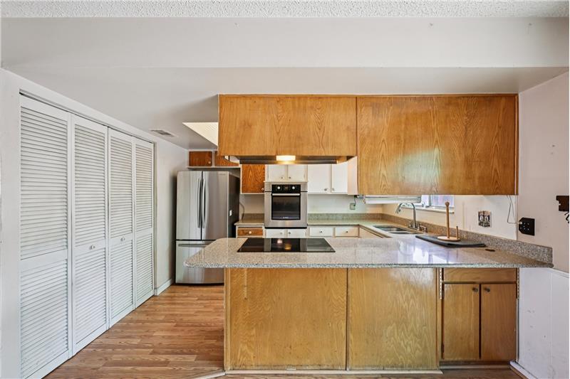 View of kitchen from dining room. Note breakfast bar