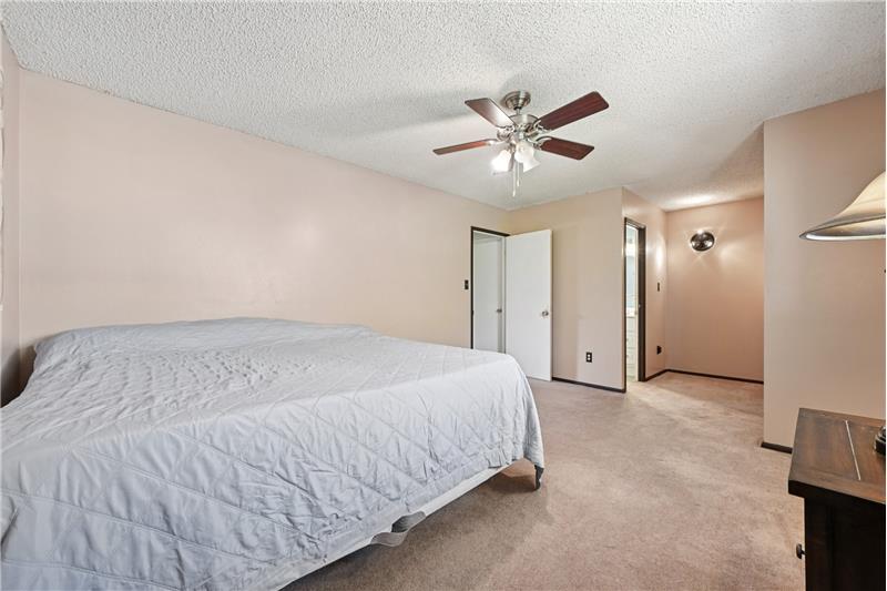 Primary bedroom with closet area and door to bathroom beyond