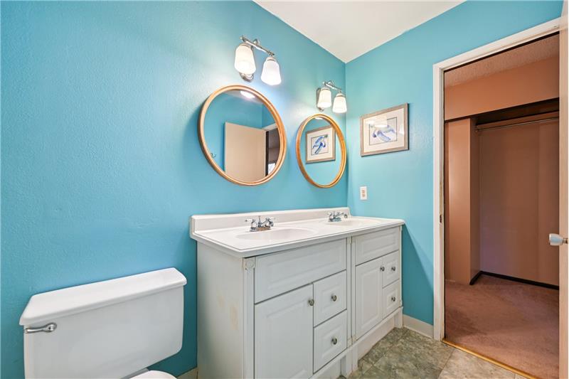 Ensuite bathroom with door to primary bedroom beyond