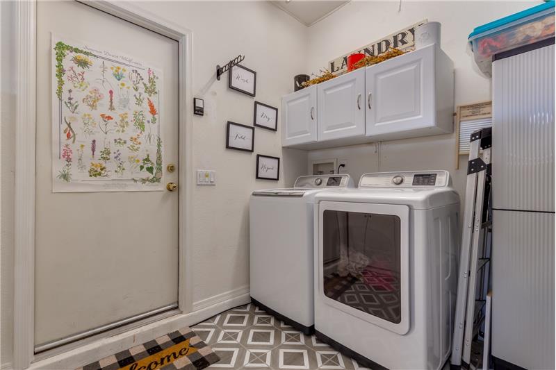 Laundry area w/storage cabinets & floor covering