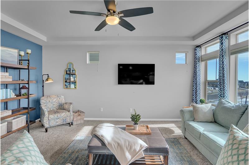 The Great Room has an accent wall, lighted ceiling fan, and neutral carpet