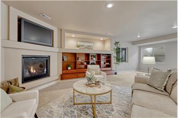 Basement Family Room with neutral carpet, gas fireplace, built-ins, and TV recess.