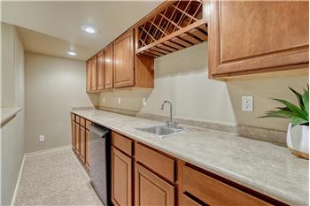 Basement wet bar with refrigerator and built-in wine rack to serve your favorite drinks and snacks.