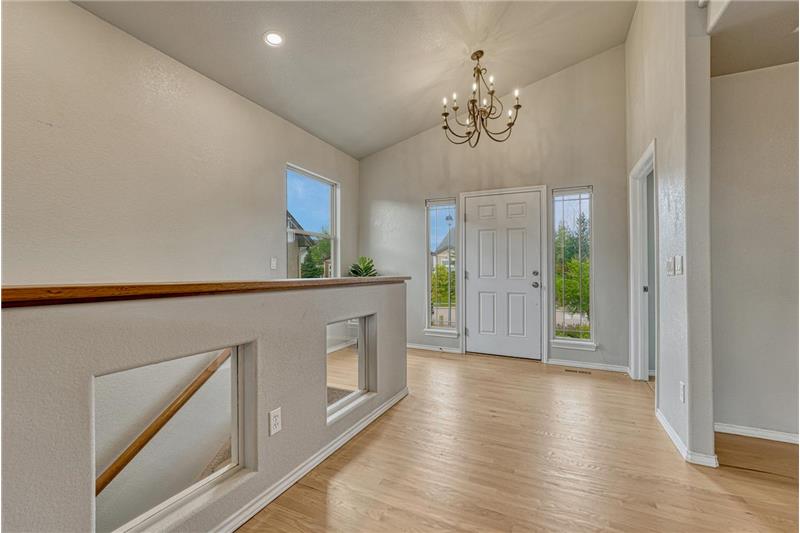 Welcoming Front Entry with wood flooring, side lite windows and an attractive light fixture.