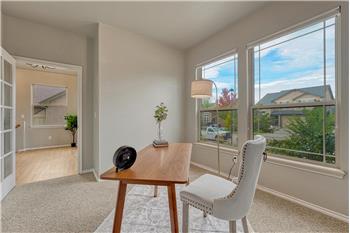 French doors lead into the front office with neutral carpet and front yard views.