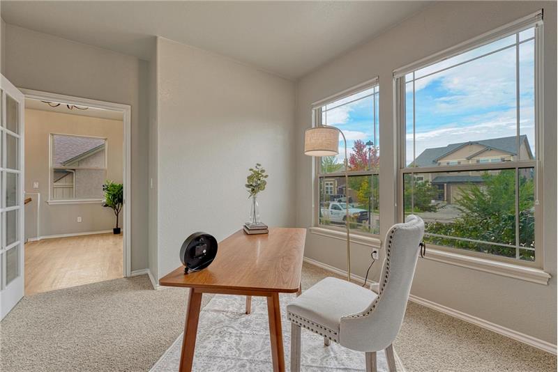French doors lead into the front office with neutral carpet and front yard views.