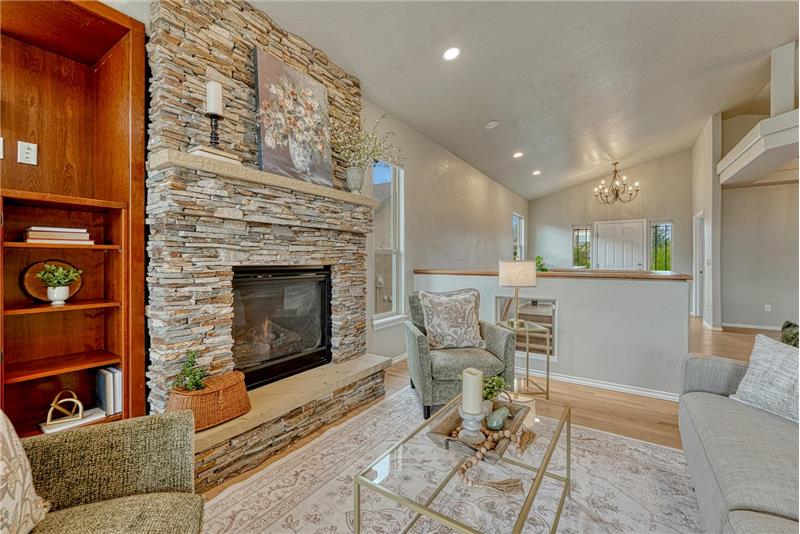 Gorgeous gas fireplace in the Great Room with floor to ceiling stone surround, raised hearth, and built-in bookshelves.