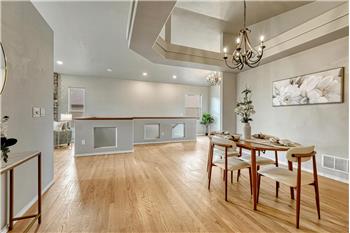 The formal Dining Room features wood flooring and a tray ceiling with attractive light fixture.