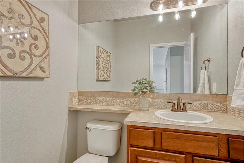 Main level Powder Bathroom with vanity and mirror.