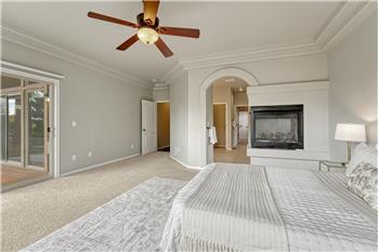 The Primary Bedroom boasts a 3-sided gas fireplace and arched entry into the adjoining 5-piece bathroom.