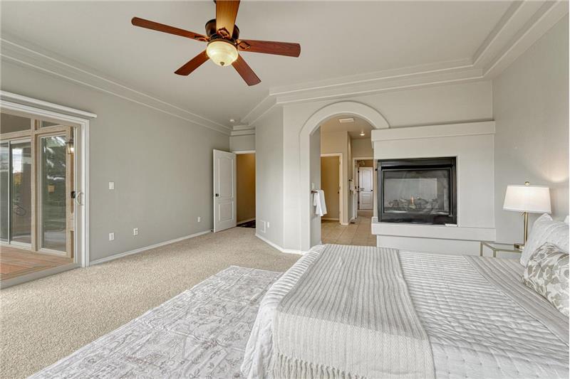 The Primary Bedroom boasts a 3-sided gas fireplace and arched entry into the adjoining 5-piece bathroom.