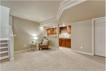 Wet Bar in the Basement Family Room that features upper and lower cabinetry, a built-in wine rack and bar fridge.