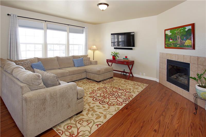 Bright living room with gas fireplace and wood laminate flooring