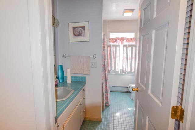First floor bathroom.  Vanity with green tile