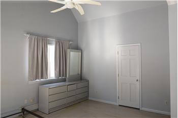 Main bedroom showing fan and door to a storage area