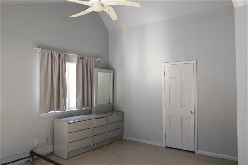 Main bedroom showing fan and door to a storage area