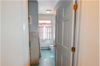 Bathroom  with green floor tile.  The window provide a view of the back yard