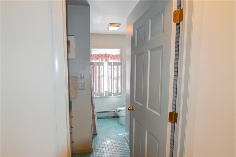 Bathroom  with green floor tile.  The window provide a view of the back yard