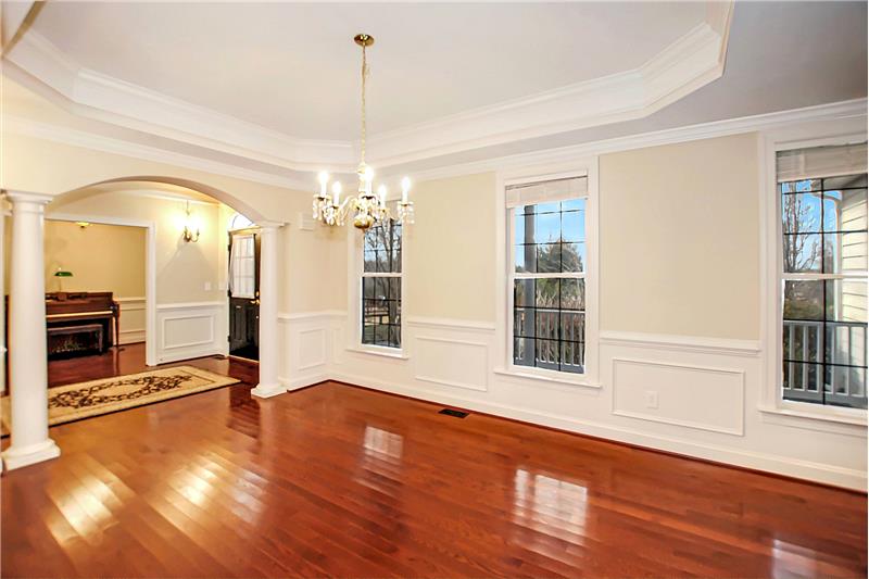 Formal dining room with tray ceiling and wainscoting
