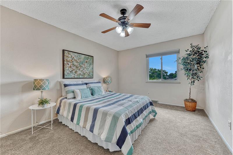 Large primary bedroom with ceiling fan, large closet, and blackout cellular blinds