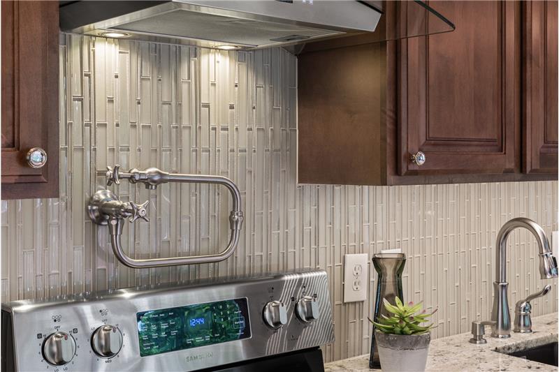 Enjoy the thoughtful updates including under cabinet lighting, an extra faucet to fill pots over the stove and a prep sink