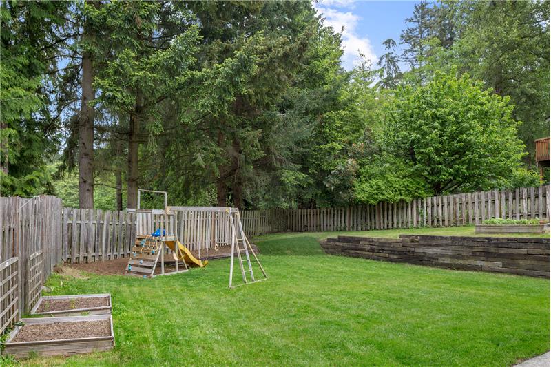 The terraced yard provides a nice level play area large enough for recreational activities, and includes 3 raised garden beds